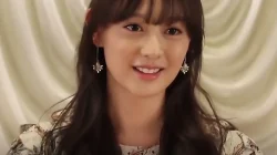 Kim Ji-won tersenyum dengan anting panjang berlatar tirai krem