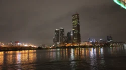 Panorama malam kawasan Yeouido Seoul dari seberang Sungai Han, gedung-gedung tinggi memantulkan cahaya ke permukaan air