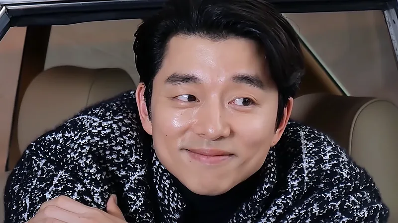 Wajah Gong Yoo tersenyum dari dekat mengenakan sweter rajut hitam putih