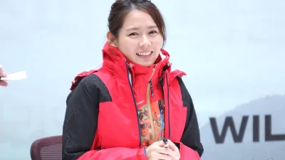 Son Ye-jin tersenyum mengenakan jaket outdoor merah pada acara jumpa penggemar
