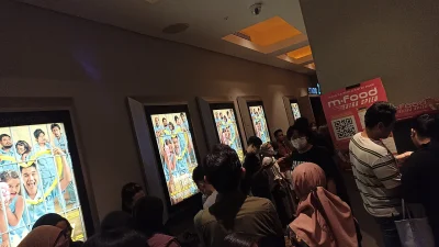 Pengunjung mengantre di lobi bioskop Indonesia di depan deretan poster film yang sedang tayang