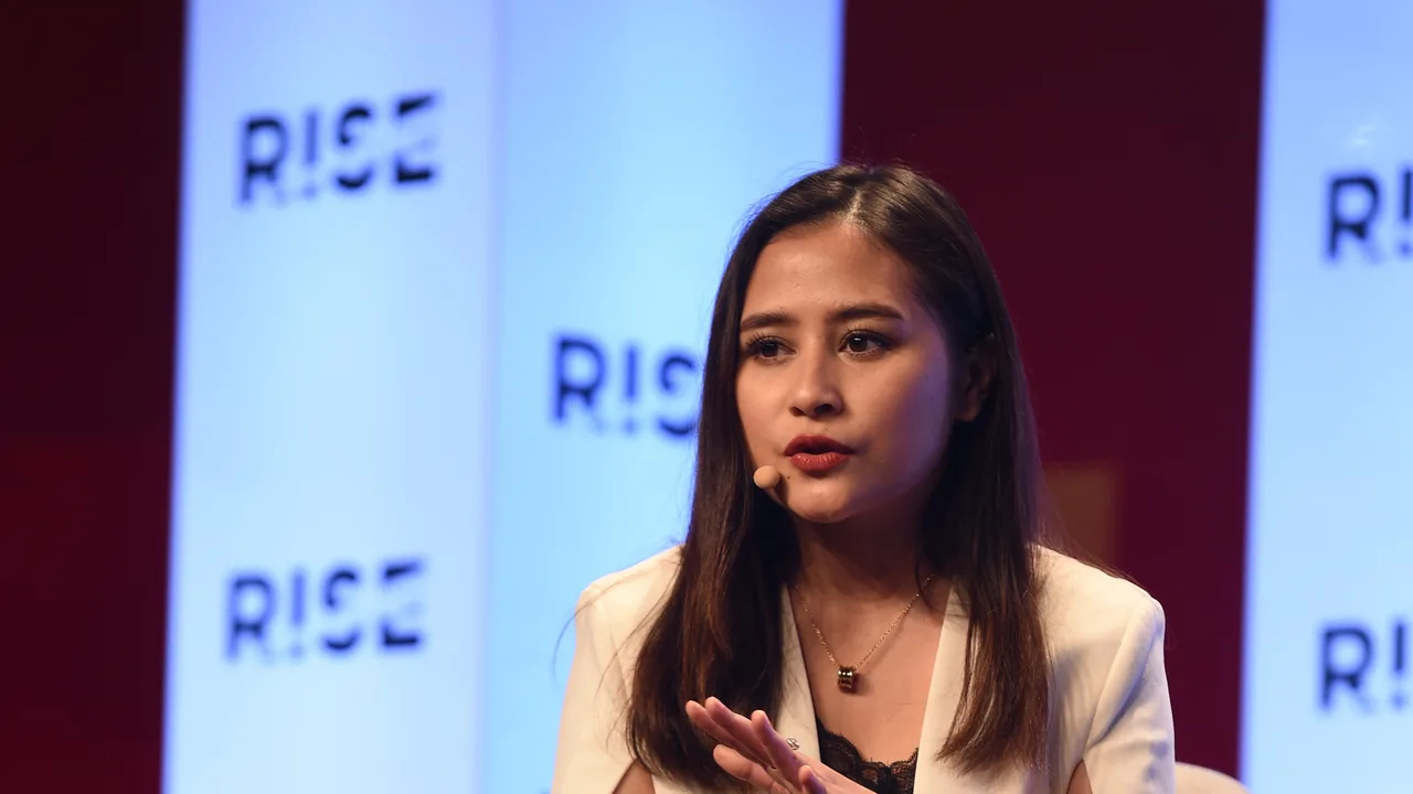 Prilly Latuconsina berbicara memakai mikrofon headset di panggung konferensi