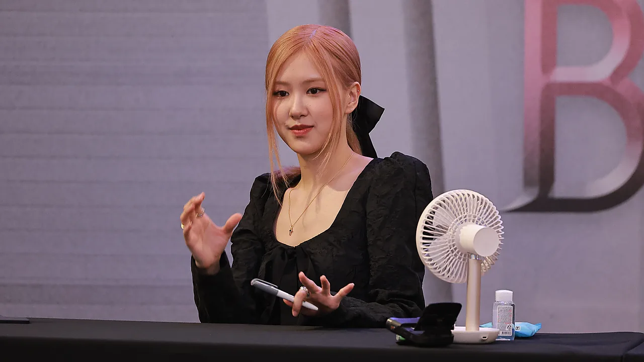 Rosé BLACKPINK berbicara sambil menggerakkan tangan di meja acara fan signing