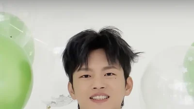 Seo In-guk tersenyum lebar dengan kemeja ungu muda di antara balon