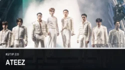 Delapan anggota ATEEZ berdiri berjajar mengenakan busana panggung serba putih di atas panggung konser pada Agustus 2024, dengan nama ATEEZ tertulis pada palang di bagian bawah gambar