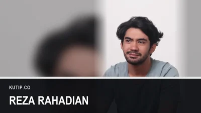 Aktor Reza Rahadian mengenakan kaus abu-abu dalam sebuah wawancara, ditempatkan di sisi kanan bingkai dengan latar buram dari foto yang sama, dengan nama Reza Rahadian tertulis pada palang di bagian bawah gambar