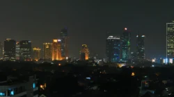 Panorama malam Jakarta dengan gedung-gedung tinggi menyala di kejauhan