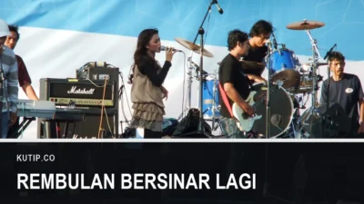 Penyanyi dangdut perempuan bernyanyi memegang mikrofon di panggung terbuka bersama pemain gitar, drum, dan keyboard, dengan tulisan Rembulan Bersinar Lagi pada palang di bagian bawah gambar