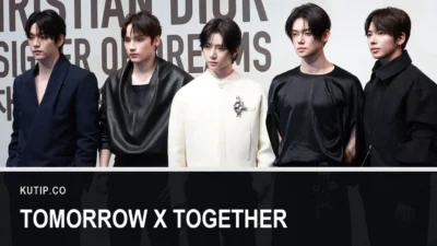 Lima anggota TOMORROW X TOGETHER berdiri berjajar mengenakan busana hitam dan putih di sebuah acara Dior pada April 2025, dengan nama Tomorrow X Together tertulis pada palang di bagian bawah gambar
